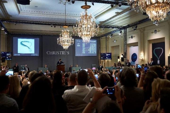Rahul Kadakia in the rostrum in Christie's Geneva selling the top lot of the Magnificent Jewels auction