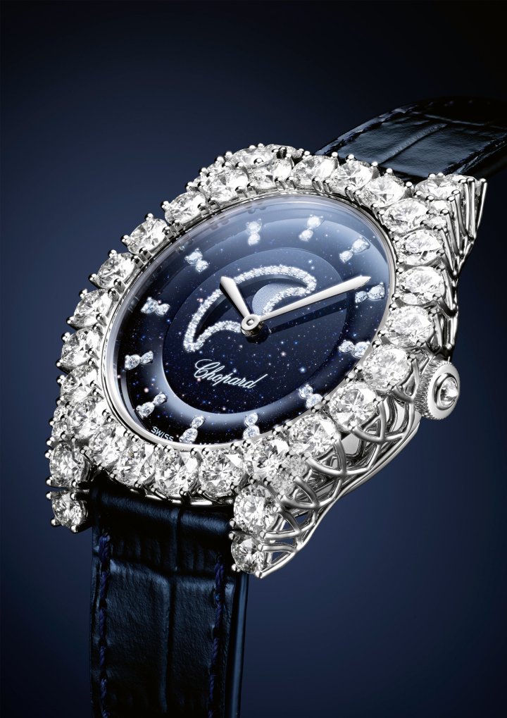L'Heure du Diamant Moonphase watch, the first complication in the L'Heure du Diamant collection. A new Chopard Manufacture mechanical movement, calibre 09.02C, with automatic winding displays the phases of the moon with a 42-hour power reserve. 18k white gold case (35.75 mm), Dial in midnight blue aventurine glass. Crown in ethical 18k white gold set with a briolette-cut diamond. Bezel and lugs in ethical 18k white gold set with brilliant-cut diamonds (3.86 carats). Crown setting enhances the brilliance of the stones by maximising light penetration. Developed by Karl Scheufele, the V-shaped prongs of this setting support the diamonds like an invisible lacework base.