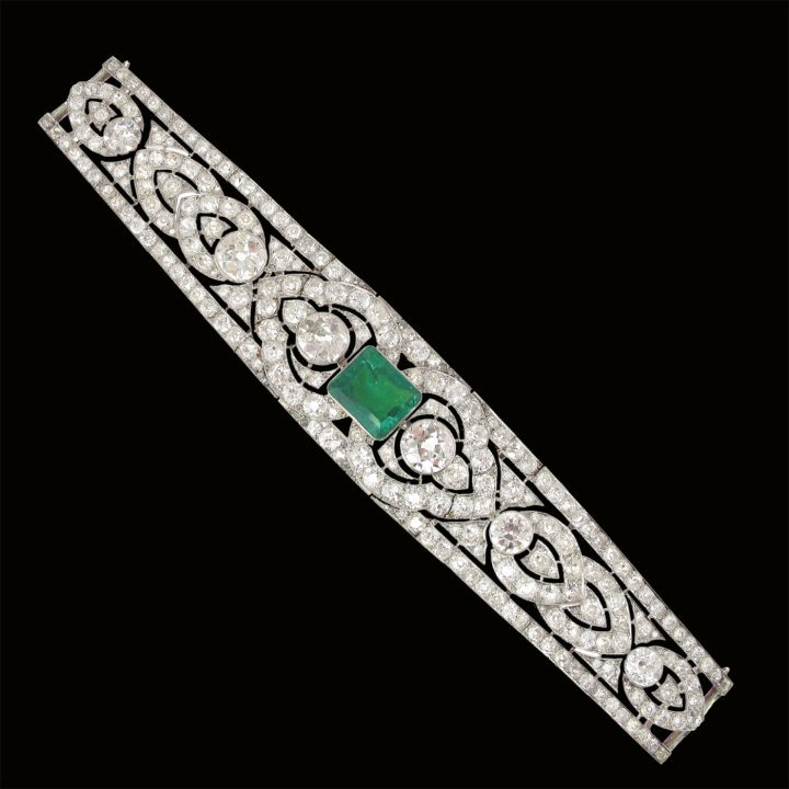 The tapering band of openwork design, centering an octagonal step-cut Columbian emerald of 11.54 carats within a surround of palmette motifs, paved with old-mine, old-European and rose-cut diamonds, in millegrain settings throughout, each panel can be detached and worn as a bracelet, the centre on screw fittings. The diamonds estimated to weigh a total of circa 77 carats, mounted in platinum, with French assay marks and makers mark for Joseph Chaumet, circa 1924, including two clasp elements of later make, maximum length 397mm. ©Faerber Collection