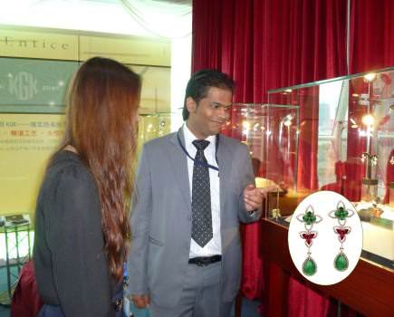Vineet Jain, Senior Marketing Executive at Entice, shows some of the Hong Kong brand's upscale diamond and gemstone jewelry. The inset is a pair of emerald, ruby, and diamond earrings.
