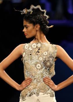 Model wearing a dragon headdress made of gemstones and diamonds in silver by Laksh Pahuja.